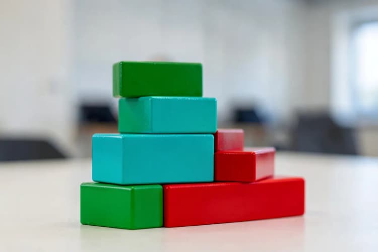 Um conjunto de blocos de construção coloridos empilhados em forma de escada, representando a preparação para projetos.