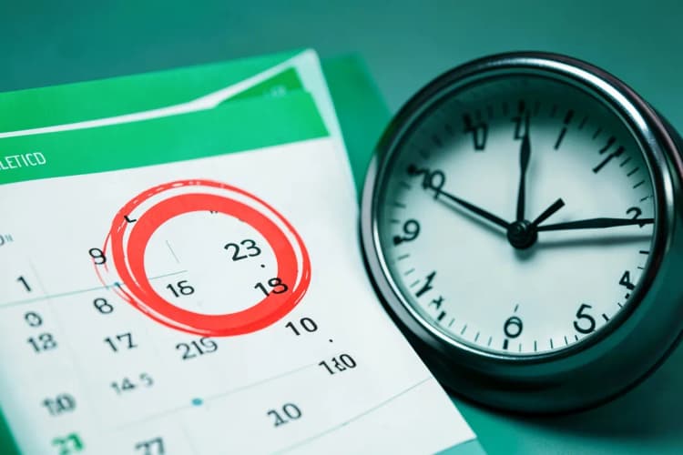 Um calendário com um dia marcado com um círculo vermelho, ao lado de um relógio.